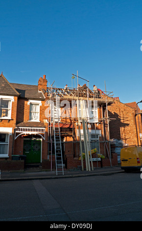 Men roofers working on a new roof on a house property in Clyde Circus London Seven Sisters N15  KATHY DEWITT Stock Photo