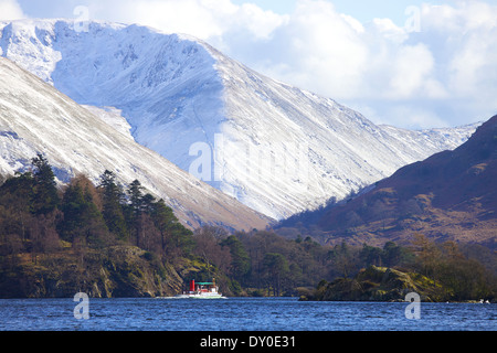 Tourists taking a trip on a steamer (boat) a lake, with Snow covered hills in the background. Ullswater, Lake District, Cumbria. Stock Photo