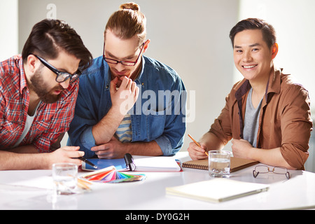 Friendly guys choosing colors from palette Stock Photo