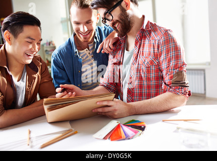 Smiling guys discussing ideas of new color for their hostel room Stock Photo