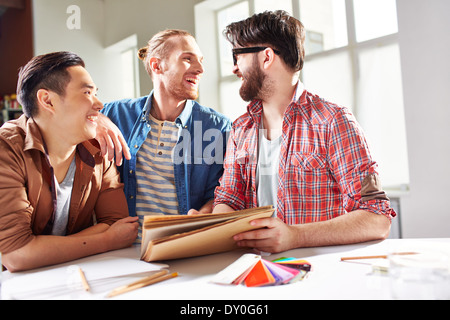 Smiling guys discussing ideas of new color for their hostel room Stock Photo