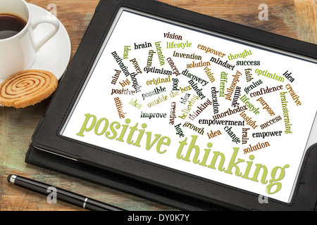 positive thinking word cloud on a digital tablet with a cup of coffee Stock Photo