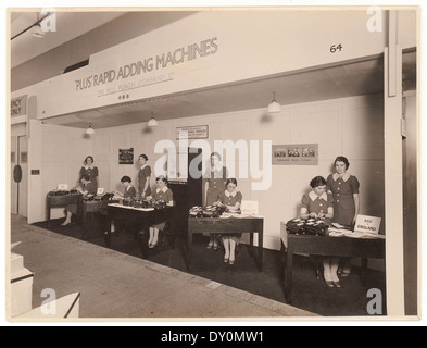 This image shows a demonstration of the Plus Rapid adding machine, a technological advancement from 1937 by Logan (Birmingham) Ltd. The machine reflects the innovation of adding machines during the early 20th century. Stock Photo
