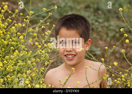 My youngest son playing out in a charming field of yellow wildflowers in south texas. Stock Photo