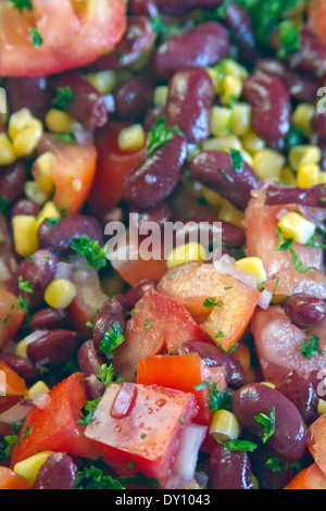 Close up of a nutritious, bean salad with kidney beans, corn, tomatoes, red onion, parsley, garlic, olive oil and lemon juice Stock Photo