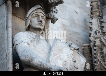 BRUSSELS, Belgium — A stone statue of a knight adorns the exterior wall of Brussels Town Hall on Grand Place. This medieval sculptural element represents part of the building's extensive Gothic decorative program. The knight figure exemplifies the detailed craftsmanship of 15th-century stone carvers who created the Town Hall's rich architectural ornament. Stock Photo