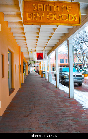 A view of the storefronts on walkway under the portico that faces the plaza of downtown Santa Fe, NM on a winter's day. Stock Photo