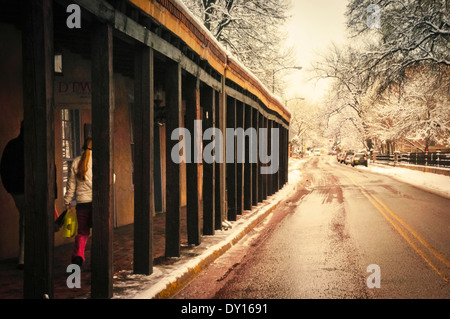 A slushy melting snow view of the storefronts along the Portico on Palace Avenue in downtown Santa Fe, NM Stock Photo