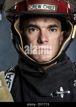 Male firefighter in structural firefighting uniform with breathing apparatus and axe Stock Photo