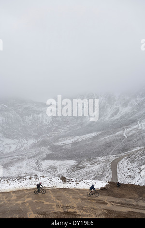 Ladakh, Jammu and Kashmir, India. Cyclists on the Khardung La, the world's highest mountain pass with a peak altitude of 18, 380 feet Stock Photo