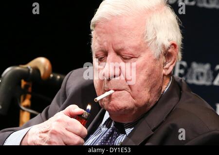 Hamburg, Germany. 02nd Apr, 2014. Former German Chancellor and co-publisher of newspaper 'Die Zeit' Helmut Schmidt (SPD) lights a cigarette on the podium during the series of events 'The long night of Die Zeit' at Schauspielhaus in Hamburg, Germany, 02 April 2014. The former German Chancellor answered collected readers' questions on Hamburg. 'Die Zeit' will for the first time be published with a local section for Hamburg on 03 April 2014. Photo: BODO MARKS/DPA/Alamy Live News