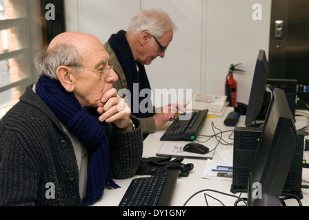 Elderly men using the computer at their local library, Alton, Hampshire, UK. Stock Photo