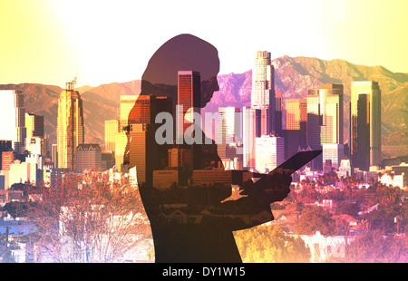 Businesswoman using a computer tablet composited with a cityscape of Los Angeles Stock Photo