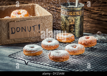 Closeup of falling powder sugar on fresh donuts Stock Photo