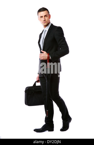 Full length portrait of a businessman standing with laptop bag and umbrella over white background Stock Photo