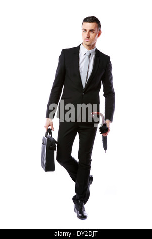 Confident businessman walking with laptop bag and umbrella isolated on a white background Stock Photo