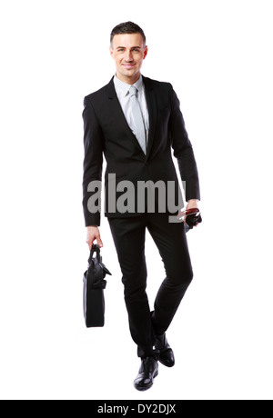 Businessman walking with laptop bag and umbrella isolated on a white background Stock Photo
