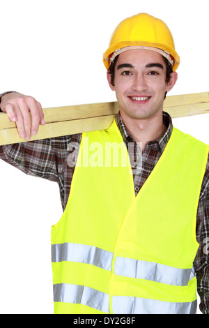 Young joiner carrying planks Stock Photo