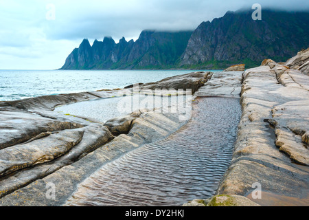 Summer night coast. The dragon's teeth rock, Jagged Ersfjord, Senja, Norway . Stock Photo