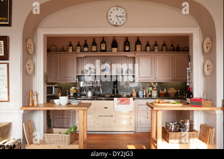 Alcoved kitchen cooking area with large aga and wooden work surfaces. The cupboards and walls are painted in Dulux 20YY 66/066 Stock Photo