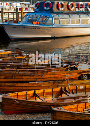 Wooden rowing boats and tourist boat moored on the jetty at Ambleside on Lake Windermere in Lake District Cumbria England UK Stock Photo