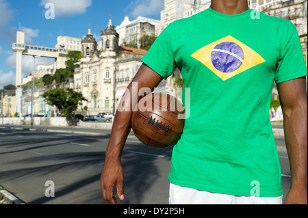 Brazilian football player standing with soccer ball at Cidade Baixa Elevador Lacerda Elevator in Salvador Brazil Stock Photo