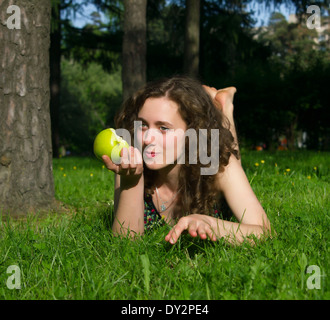 beautiful young woman eating apple outdoors in spring Stock Photo