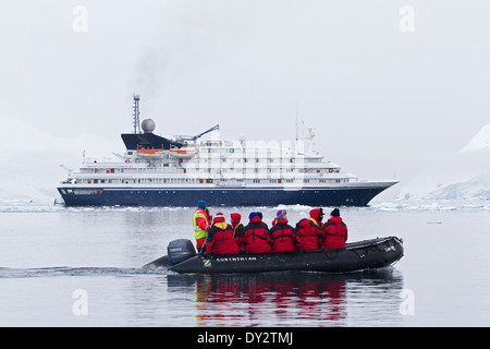 Antarctica cruise ship Antarctica tourism expedition with tourists and Zodiac among glacier and ice on Antarctic Peninsula. Stock Photo