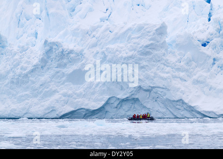 Antarctica tourism among the landscape of iceberg, glacier, and ice with tourists in zodiac. Antarctic Peninsula.