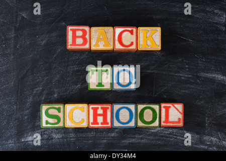 Childrens blocks spelling out Back To School on a chalk board. Horizontal format. Stock Photo