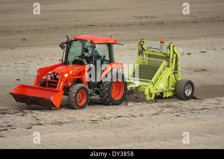 Mechanical beach cleaning - Raking strandline at Looe, Cornwall Stock Photo