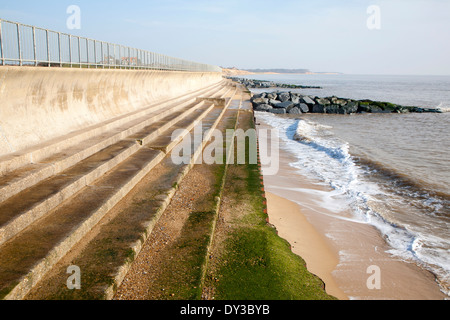 Curved Sea wall, steps and rock armour groynes, forming coastal defences at Southwold, Suffolk, England Stock Photo