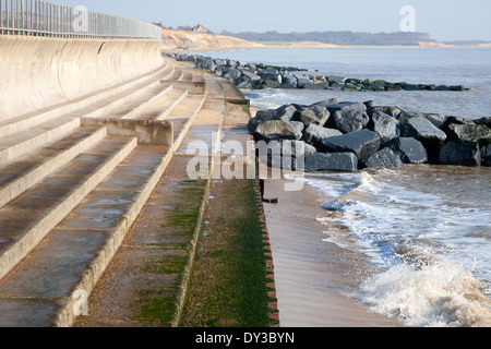 Curved Sea wall, steps and rock armour groynes, forming coastal defences at Southwold, Suffolk, England Stock Photo