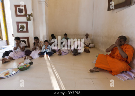 Anuradhapura, Sri Lanka. Sri Maha Bodhi temple. Buddhists praying in the main assembly hall Stock Photo