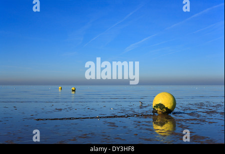 Yellow buoys on Heacham beach at low tide. Stock Photo