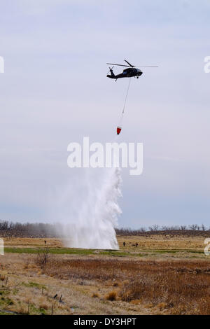 Commerce City, Colorado USA - 5th April 2014. Members of the Boulder Fire Department and the Colorado National Guard 2nd Battalion, 135th General Support Aviation Brigade based out of Buckley Air Force Base in Aurora, Colorado practice their communication and bucket drop techniques at The Rocky Mountain Arsenal National Wildlife Refuge in preparation for Colorado’s upcoming fire season. This is the first year that firefighters on the ground are able to communicate with those in the air to coordinate the firefighting effort. Credit:  Ed Endicott/Alamy Live News Stock Photo