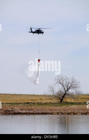 Commerce City, Colorado USA - 5th April 2014. Members of the Boulder Fire Department and the Colorado National Guard 2nd Battalion, 135th General Support Aviation Brigade based out of Buckley Air Force Base in Aurora, Colorado practice their communication and bucket drop techniques at The Rocky Mountain Arsenal National Wildlife Refuge in preparation for Colorado’s upcoming fire season. This is the first year that firefighters on the ground are able to communicate with those in the air to coordinate the firefighting effort. Credit:  Ed Endicott/Alamy Live News Stock Photo