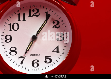 A red vintage alarm clock face on a red background Stock Photo