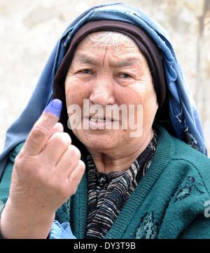 Kabul, Afghanistan. 5th Apr, 2014. An Afghan woman shows her inked finger after casting her ballot at a polling center in Kabul, Afghanistan, on April 5, 2014. The polling for Afghanistan's presidential election concluded on Saturday and counting of ballots has begun, the country's election officials said. A total of 6,218 polling centers remained open on the election day and around 7 million eligible voters, 36 percent of them women, had cast their votes. Credit:  Omid/Xinhua/Alamy Live News Stock Photo