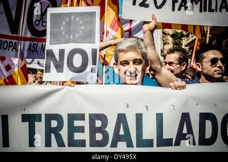 Barcelona, Spain. April 6th, 2014: A protestor with his placard marches behind a banner for a social Catalonia through the city of Barcelona. Credit:  matthi/Alamy Live News Stock Photo