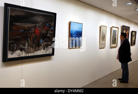 Hong Kong, China. 7th Apr, 2014. A visitor views paintings during the preview of Christie's Hong Kong 2014 spring season in Hong Kong, south China, April 7, 2014. The auction will be held from May 24 to 28. © Li Peng/Xinhua/Alamy Live News Stock Photo