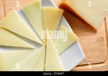 closeup of a piece and some slices of manchego cheese from Spain Stock Photo