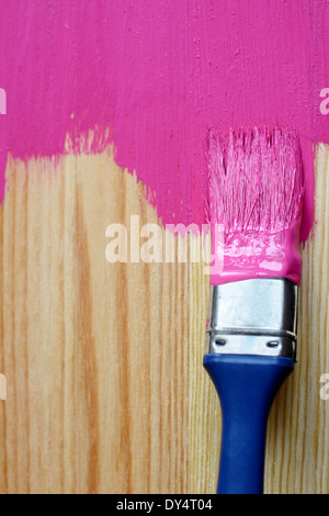 Closeup of pine plank being painted in a bright colour, with copy space Stock Photo