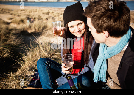 Couple celebrating with white wine at coast, Bournemouth, Dorset, UK Stock Photo