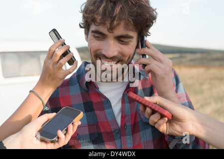 Young man on cell phone with hands holding smartphones Stock Photo