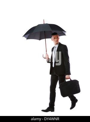 Businessman walking with umbrella and laptop bag isolated on a white background Stock Photo