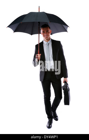 Businessman walking with umbrella and laptop bag isolated on a white background Stock Photo