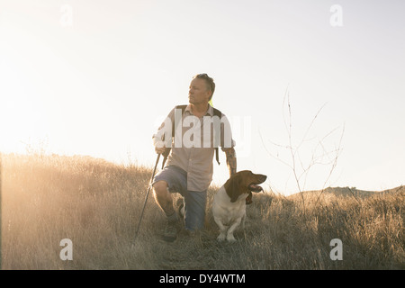 Mature man and his basset hound taking a break from hiking in Santa Monica Mountains, California, USA Stock Photo