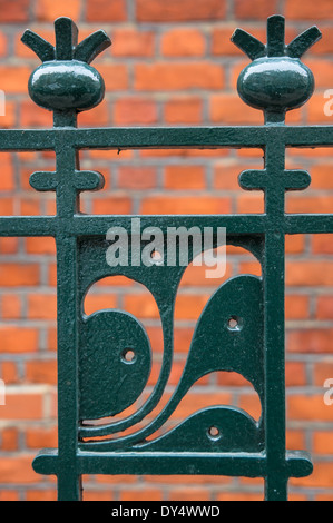 Decorative metal fencing with red bricks in the background Stock Photo