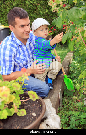 young father with his son working in the garden Stock Photo